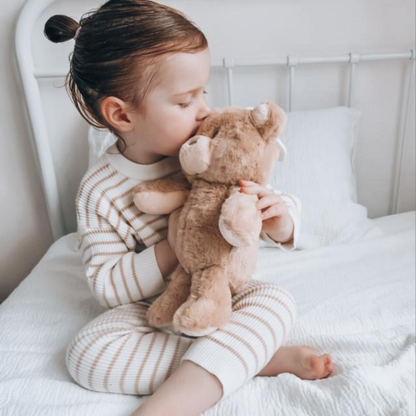Toddler hugging sleep toy affirmation teddy bear during bedtime routine